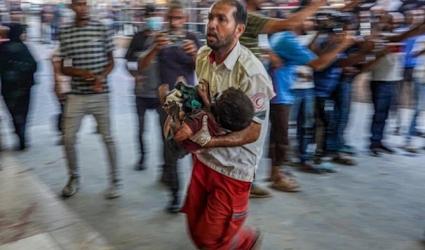 A paramedic carries a Palestinian child wounded during Israeli bomabadment to the emergency ward at the Naser Hospital in Khan Younis, southern Gaza, July 9,2024. (AFP)