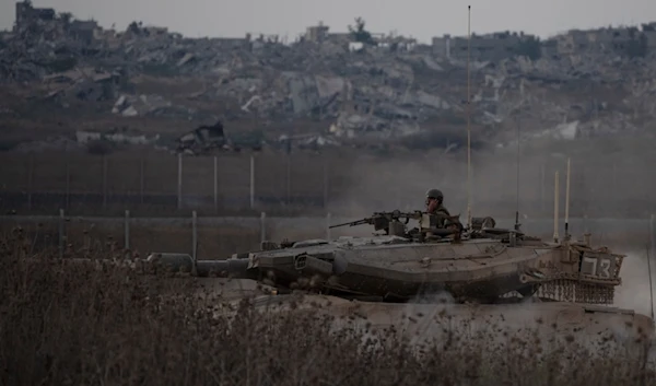 Israeli soldiers move on the top of a tank near the Gaza border, as seen from southern occupied Palestine, Wednesday, Aug. 21, 2024. (AP