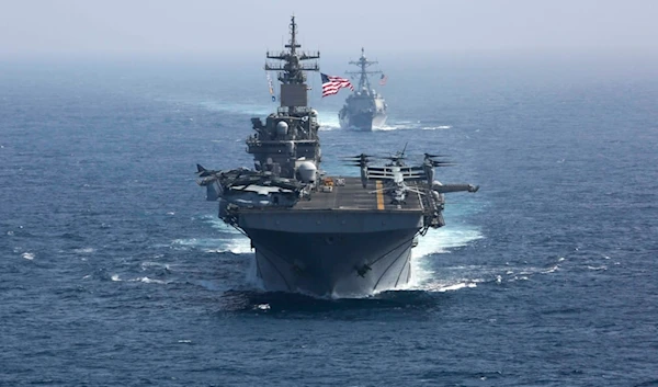 The amphibious assault ship USS Kearsarge and the Arleigh Burke-class guided-missile destroyer USS Bainbridge sail as part of the USS Abraham Lincoln aircraft carrier strike group in the Arabian Sea.