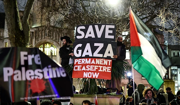 Pro-Palestinian demonstrators wave Palestinian flags and hold placards as they protest in Parliament Square in London on February 21, 2024. (AFP)