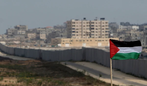 A Palestinian flag is seen with the background of a section of the wall in the Philadelphi corridor between Egypt and Gaza, on the background, near the southern Gaza Strip town of Rafah, Sunday, July 1, 2007. (AP)