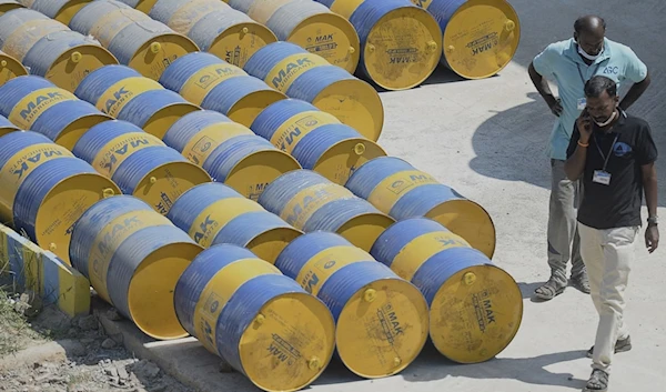 Workers walk past oil barrels at a filling station in Chennai, India on February 24, 2022. (AFP)