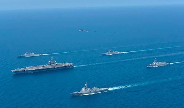 This photo shows USS Abraham Lincoln, left, and JS Kongo, front, sail in formation during a US-Japan bilateral exercise at the Sea of Japan on April 12, 2022.