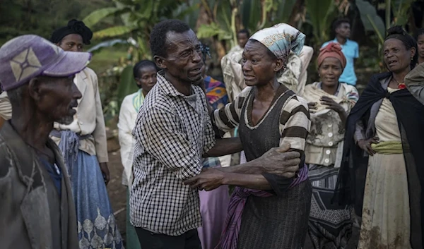 A man and a woman react while residents and volunteers leave for the night after digging in the mud in search for survivors and bodies at the scene of a landslide in Gofa on July 24, 2024.(AFP)