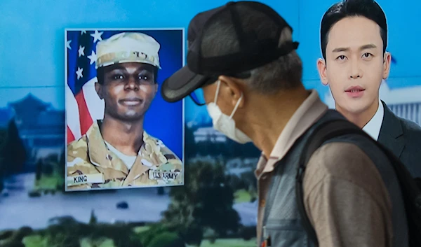 In this photo taken in Seoul on August 16,2023, a man walks past a television showing a news broadcast featuring a photo of US soldier Travis King . (AFP)