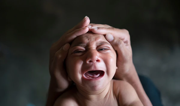 Elielson tries to calm down his baby brother Jose Wesley, in Bonito, Pernambuco state, Brazil on Jan. 30, 2016. (AP)