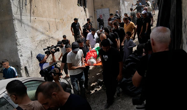 Palestinian mourners carry the body of Ayed Abu Al-Hija, 64, who was killed during the recent Israeli aggression in the occupied West Bank, during his funeral in the refugee camp of Nur Shams, Tulkarm, occupied Palestine, August 30, 2024 (AP)