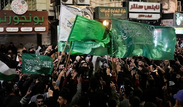 Palestinians wave Hamas flags as they celebrate the Israeli occupation's forced release of Palestinian detainees in the West Bank city of Nablus, Palestine, Nov. 24, 2023. (AP)