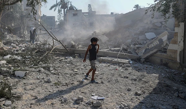 A Palestinian boy walks past the rubble of a school destroyed in an Israeli airstrike on Deir al-Balah, central Gaza Strip, Saturday, July 27, 2024. (AP)