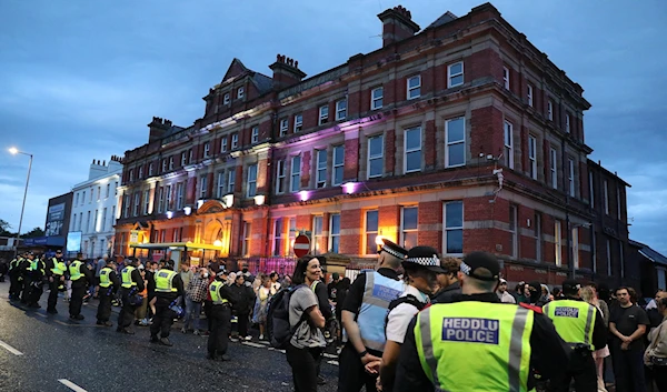 Liverpool residents showed solidarity with the Muslim community by turning up at a local mosque after reports far-right agitators planned to target it, August 2, 2024. (AFP)