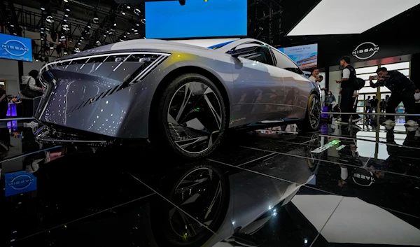 A visitor takes a photo of a Nissan EVO Concept car model on display during the Auto China 2024 in Beijing, Sunday, April 28, 2024. (AP)