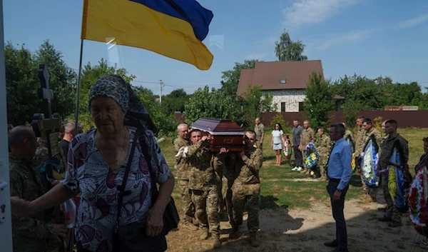 A guard of honour carry the coffin of their comrade Volodymyr Grechanyi, a Ukrainian serviceman, during the funeral ceremony in the village of Putrivka, Ukraine, Thursday, Aug. 1, 2024.  (AP)