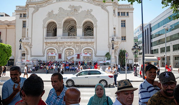 A supporter of Tunisian President Kais Saied speaks about the current situation in their country opposite the Municipal Theatre at Habib Bourguiba Avenue in Tunis, Thursday, July 25, 2024 (AP)