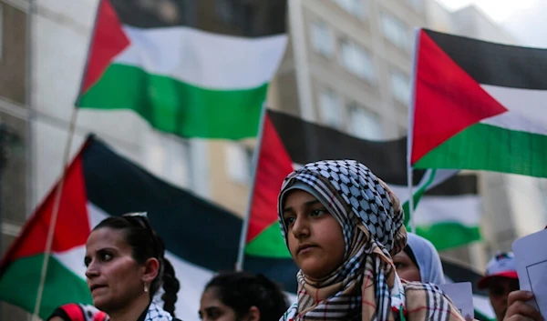 Women hold Palestinian flags during a demonstration against Israel's military offensive in Gaza, Tuesday, July 22, 2014, in Berlin, Germany (AP)