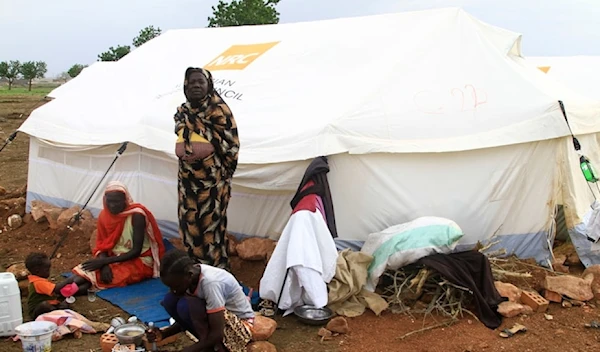 Women and children sit outside their tent, set up at a camp for internally displaced Sudanese from Sennar state, in the al-Huri district of Gedaref city east of war-torn Sudan on July 14,2024. (AFP)