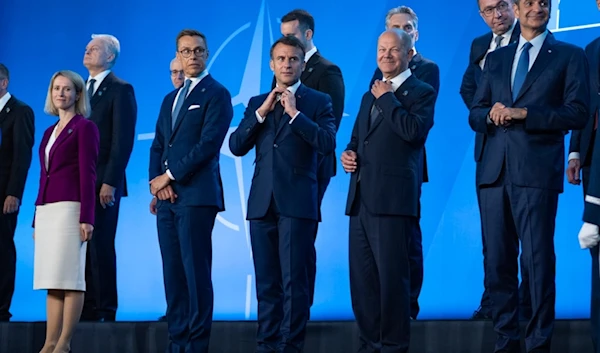 French President Emmanuel Macron and German Chancellor Olaf Scholz adjust their ties before a family photo at the NATO Summit, Wednesday, July 10, 2024, in Washington, the United States (AP Photo)