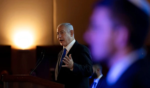 Israeli occupation Prime Minister Benjamin Netanyahu addresses the annual National Leadership Mission of the Conference of Presidents of Major American Jewish Organizations, in al-Quds, Palestine, Feb. 19, 2023. (AP)