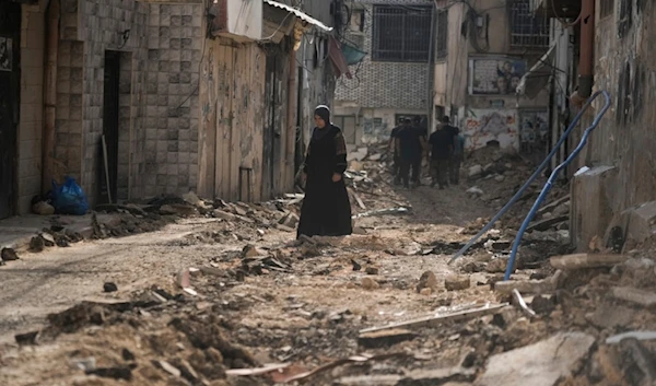 Palestinians walk on a damaged road following Israeli aggression in the West Bank city of Jenin on Friday, September 6, 2024 (AP)