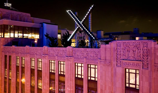 Workers install lighting on an "X" sign atop the company headquarters, formerly known as Twitter, in downtown San Francisco, on Friday, July 28, 2023. (AP)