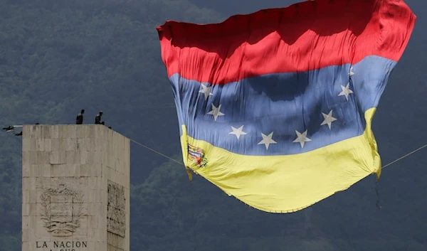 A Venezuelan national flag strung from The Walk of the Heroes monument flutters in the wind before the start of an Independence Day military parade, in Caracas, Venezuela, Friday, July 5, 2024.