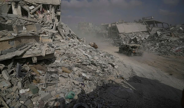 Israeli soldiers drive next to destroyed buildings following Israeli strikes during a ground operation in the Gaza Strip on Friday, September 13, 2024 (AP)