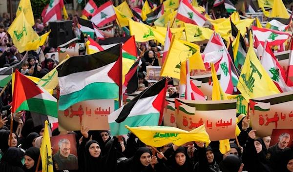 Lebanese protesters hold Hezbollah and Palestinian flags during a protest to show their solidarity with the Palestinians, in the southern suburb of Beirut, Lebanon, Oct. 13, 2023. (AP)