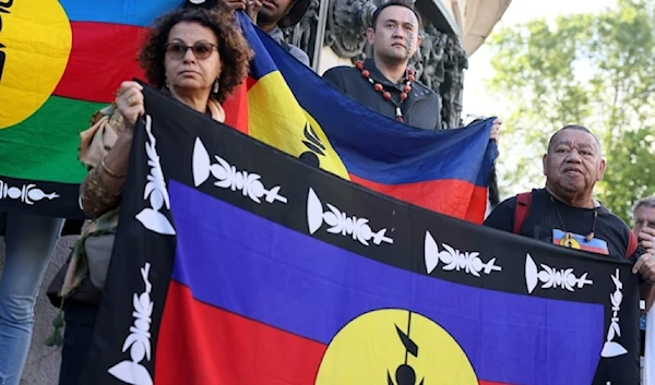 Demonstrators hold Kanak and socialist National Liberation Front (FLNKS) flags during a gathering in Paris, on May 16, 2024. (AP)