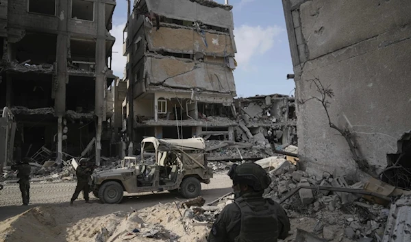 Israeli occupation take up position next to buildings destroyed by the Israeli military in the Gaza Strip on Friday, September 13, 2024. (AP)