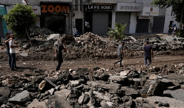 Palestinian walk on a street damaged during the Israeli incursion in the West Bank city of Jenin, Sunday, Sept. 1, 2024. (AP)