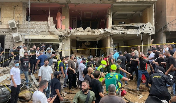 People gather near a damaged building at the scene of an Israeli missile strike in the Southern Suburb of Beirut, Friday, September 20, 2024 (AP)