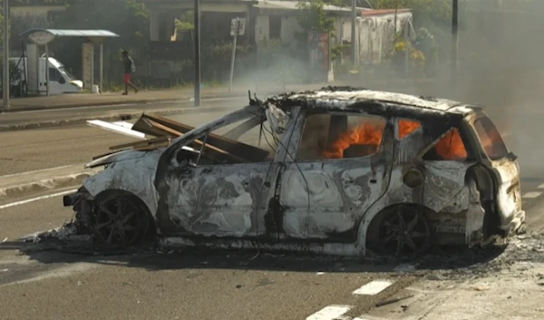 A car burns in Martinique on Tuesday following a night of riots amid protests over the high cost of living. (AFP/Getty Images)