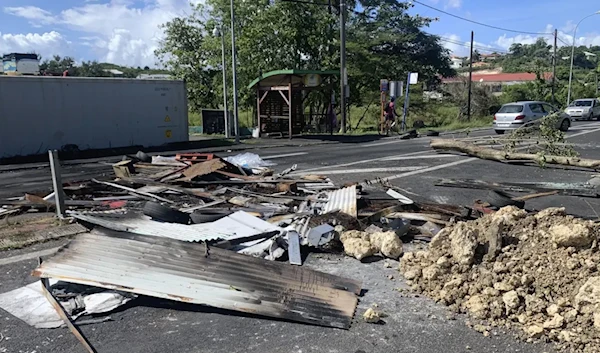 Debris left by demonstrators block a street of Le Gosier Sunday November 21, 2021. (AP)