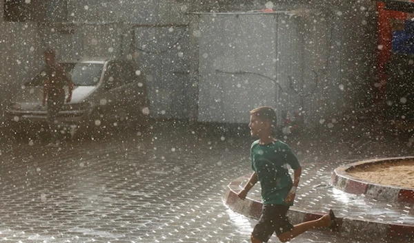 A forcibly displaced Palestinian child running under the rain on September 3,2024. (UNRWA)