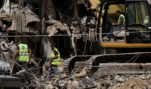 Emergency workers clear the rubble at the site of Friday's Israeli strike in Beirut's Southern Suburb, Sunday, September 22, 2024 (AP)