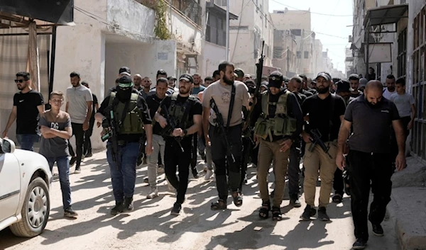 Palestinian freedom fighters march during a funeral for martyred Palestinians draped in the Hamas flag and killed in an Israeli airstrike in the Jenin refugee camp, in the West Bank city of Jenin, August 18,2024. (AP)