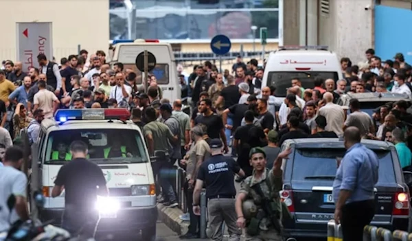 Ambulances surrounded by a crowd of people outside a Beirut hospital, in the aftermath of the electronic attacks (AFP)