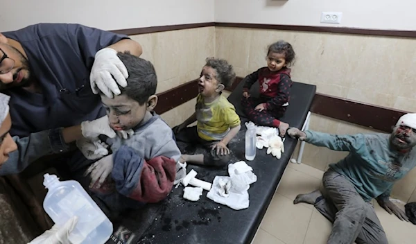 A Palestinian father and his three children wounded in an Israeli bombardment of the Gaza Strip are treated at al Aqsa Hospital on Deir al-Balah, Gaza, on November 21, 2023 (AP)