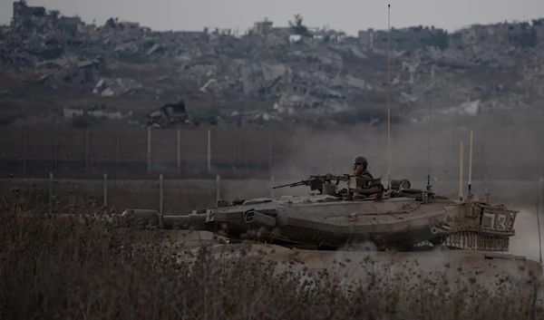 Israeli soldiers move on the top of a tank near the Gaza border, as seen from southern occupied Palestine, on August 21, 2024. (AP)