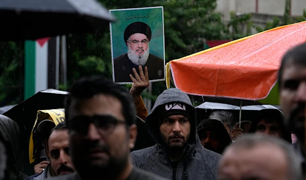 An Iranian demonstrator holds up a poster of the leader of Lebanon's militant Hezbollah group Hassan Nasrallah in a gathering to support Hezbollah at the Felestin (Palestine) Square in downtown Tehran, Iran, on September 28, 2024. (AP)