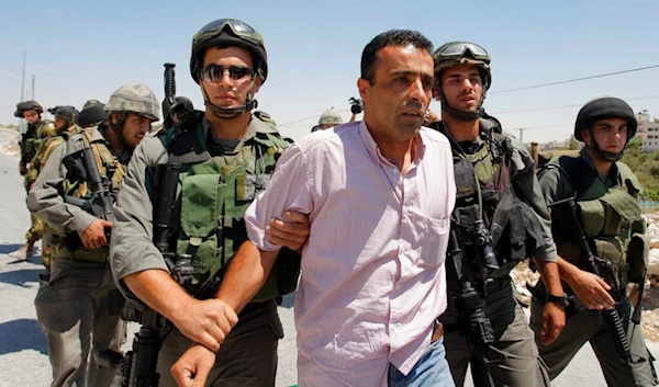 A Palestinian protester is detained during a demonstration against the Israeli separation barrier in the West Bank village of Maasarah, July 16, 2010. (AP)