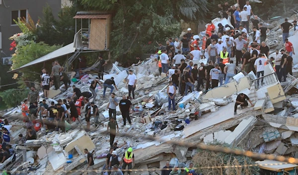 People and rescue workers search for victims after an Israeli airstrike hit two adjacent buildings, in Ain el-Delb neighborhood east of the southern port city of Sidon, Lebanon, Sunday, September 29, 2024 (AP)