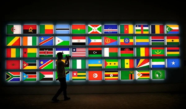 A cameraman films African national flags on display at the media center during the opening ceremony of the China Africa Forum, in Beijing, Thursday, Sept. 5, 2024. (AP Photo/Andy Wong)