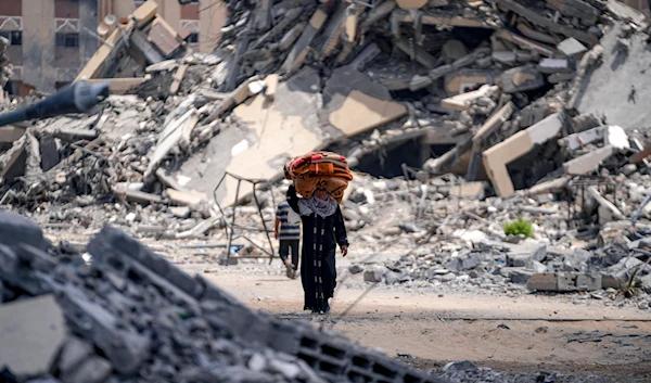 A Palestinian displaced woman by the Israeli air and ground offensive on the Gaza Strip flees from Hamad City, following an evacuation order by the Israeli army to leave parts of the southern area of Khan Younis, August 11, 2024. (AP)