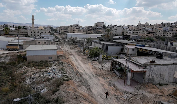 A man walks on a damaged road following an Israeli army raid in Jenin, West Bank, on September 4, 2024. (AP)