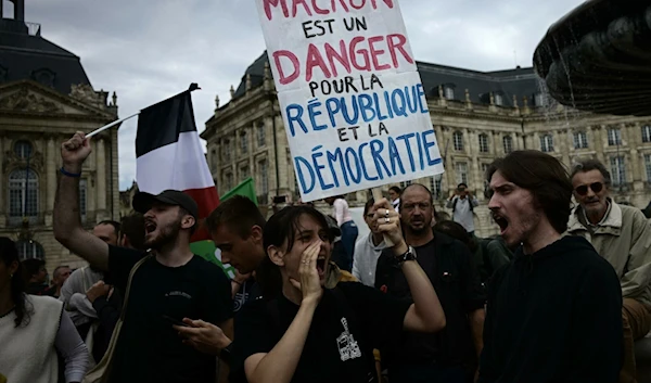 Protester holds a banner reading "Macron is a danger to the Republic and Democracy," September 7, 2024. (@le_Parisien)