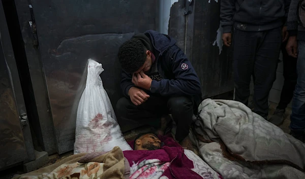 Kareem Al-Dabaji mourns his brother Anas Al-Dabaji, who was killed in an Israeli airstrike that hit an apartment in Deir Al-Balah, at Al-Aqsa Hospital morgue in Deir Al-Balah, Gaza, on January 9, 2025. (AP)