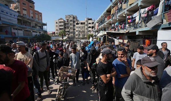 Palestinians gather to receive aid distributed by UNRWA, the UN agency helping Palestinian refugees, in Nusairat refugee camp, Gaza, on November 5, 2024 (AP)