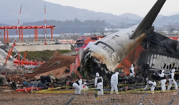 Rescue team members work at the site of a plane crash at Muan International Airport in Muan, South Korea, December 31, 2024. (AP)