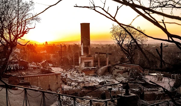 The sun rises behind a home destroyed by the Palisades Fire in the Pacific Palisades community of Los Angeles on Sunday, Jan. 12, 2025, (AP Photo/Noah Berger)