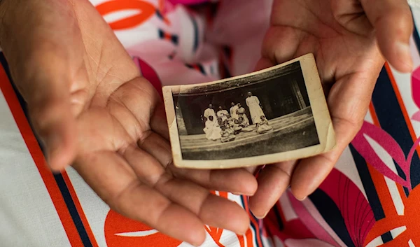 Monique Bitu Bingi, one of the plaintiffs in the case, holds holds a photo of herself as a young girl before she was forcibly removed from her parents. Photograph: Francisco Seco/AP